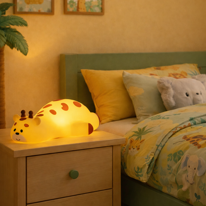 Veilleuse Girafe Lampimou posée sur la table de chevet dans une chambre d'enfant à la décoration savane/jungle.